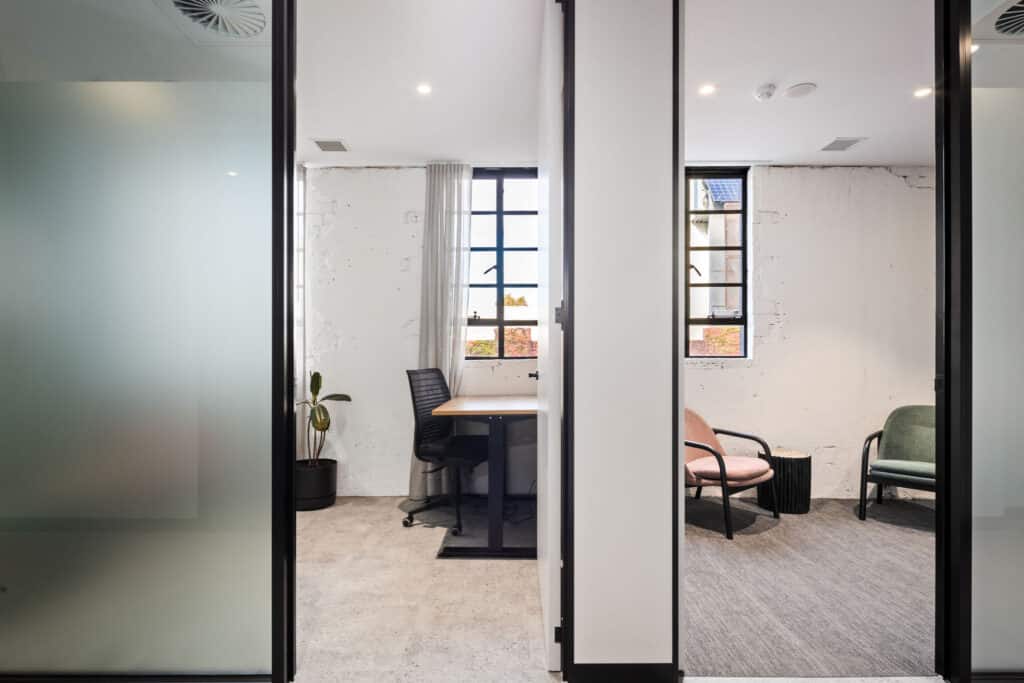 side-by-side consultation rooms with white walls, high ceilings and soft colours.