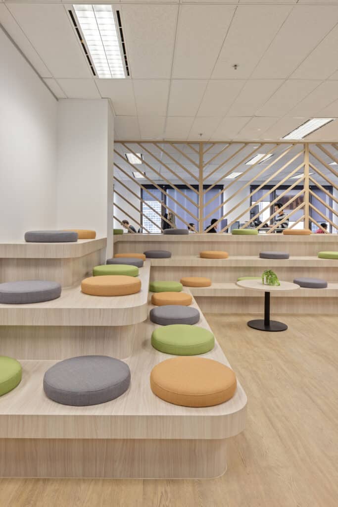 A vibrant, open-plan workspace with custom grandstand joinery designed for company meetings and breakout sessions.